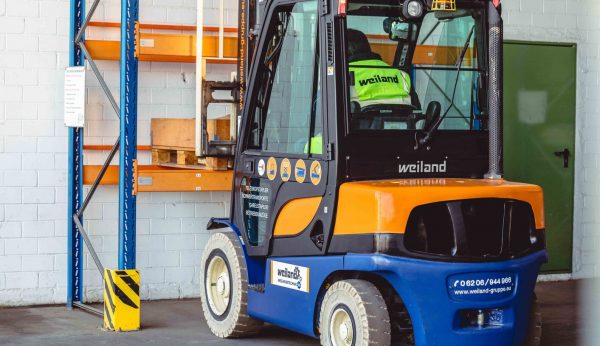 Weiland Gabelstapler beim Palettenhandling in einer Lagerhalle, ideal für effizienten Materialtransport.